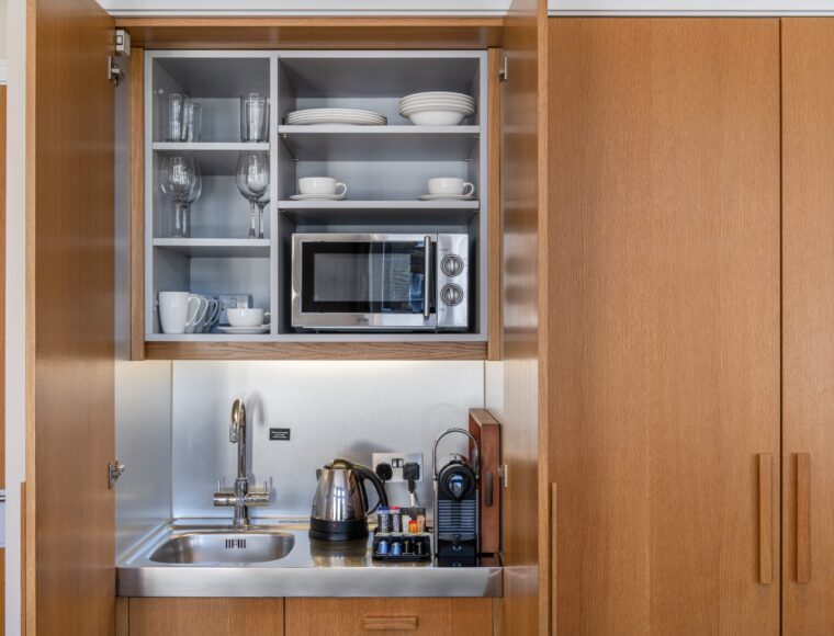 A miniature kitchen, with a built in fridge and microwave, located in Kensington.