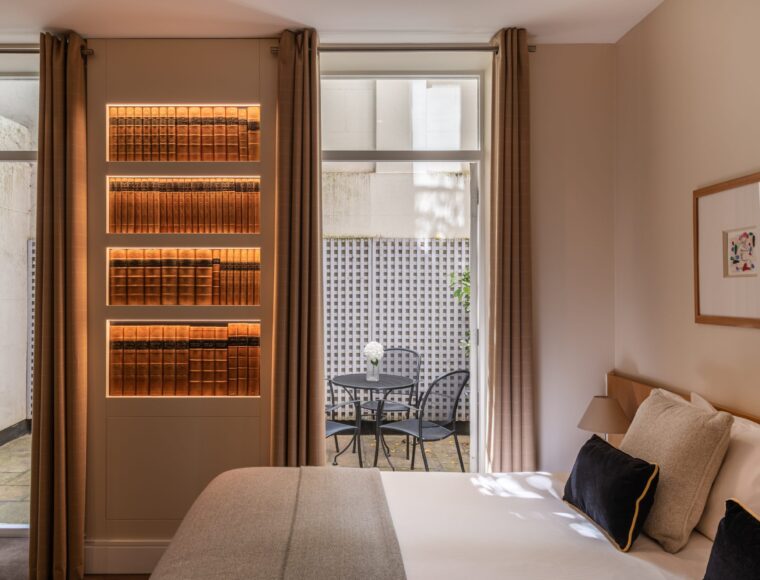A deluxe room with a double bed, built in shelves and a patio located in Kensington.