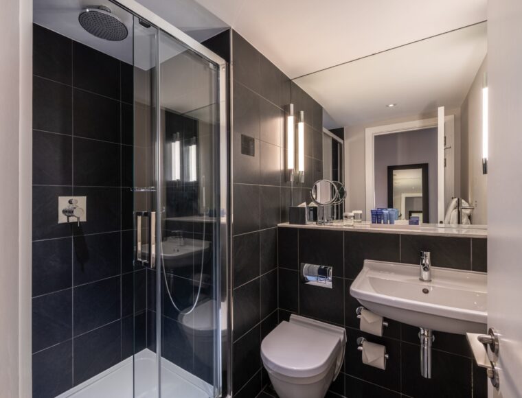 A single room bathroom with a walk-in shower, located in Soho.