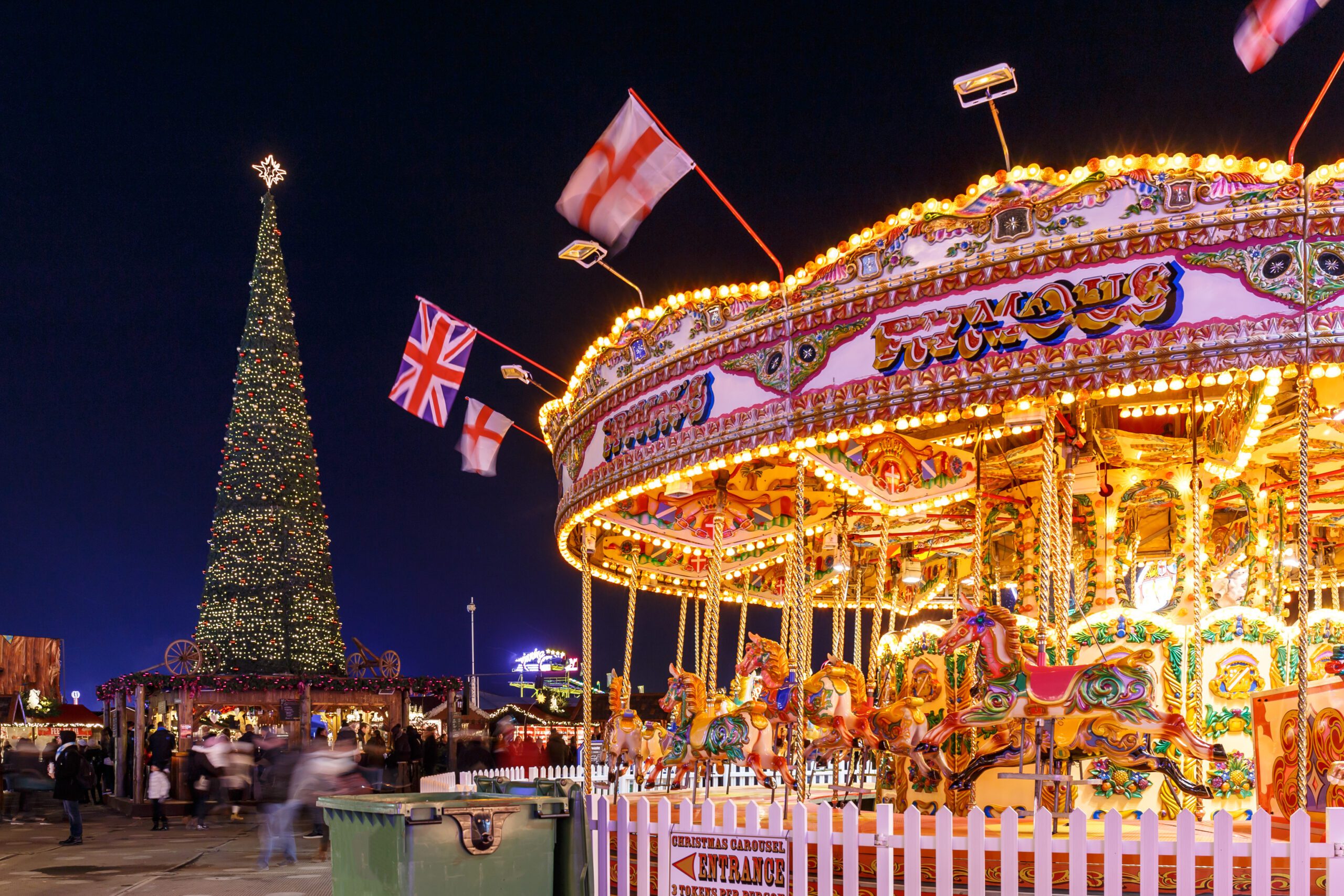 London Christmas Market at Hyde Park Winter Hyde Parke. Wonderland London. The scene also includes a well lit Horse Carousel Ride in the foreground of Winter Wonderland