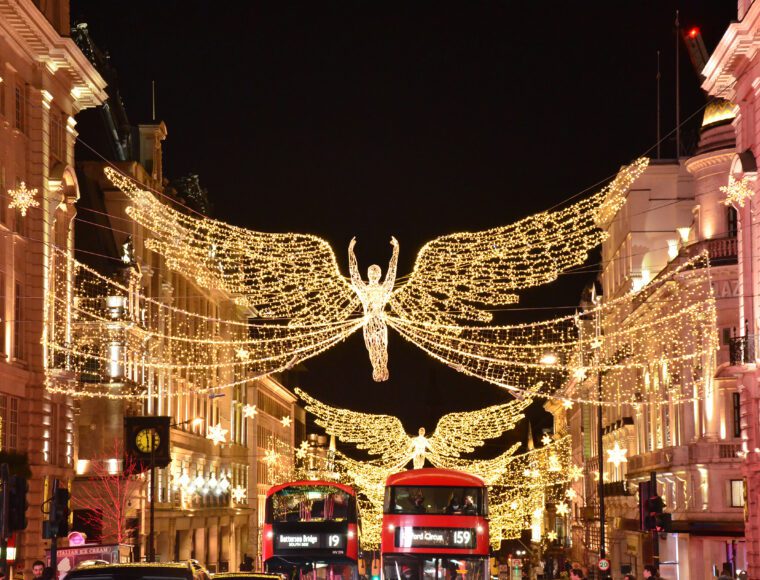 London Christmas Lights in Piccadilly Circus and Oxford Street. Angel Christmas Lights hanging over two London buses at Christmas.