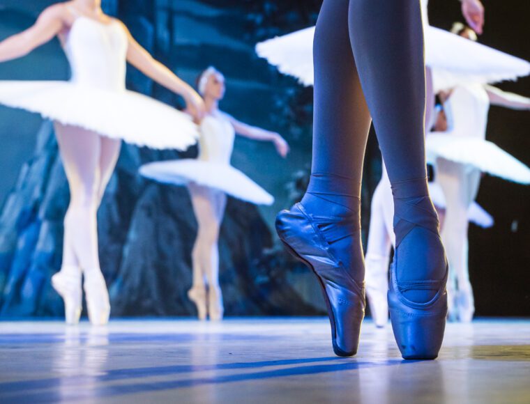 Legs of ballerinas dancing in ballet Swan Lake at Theatre in London at Christmas time.